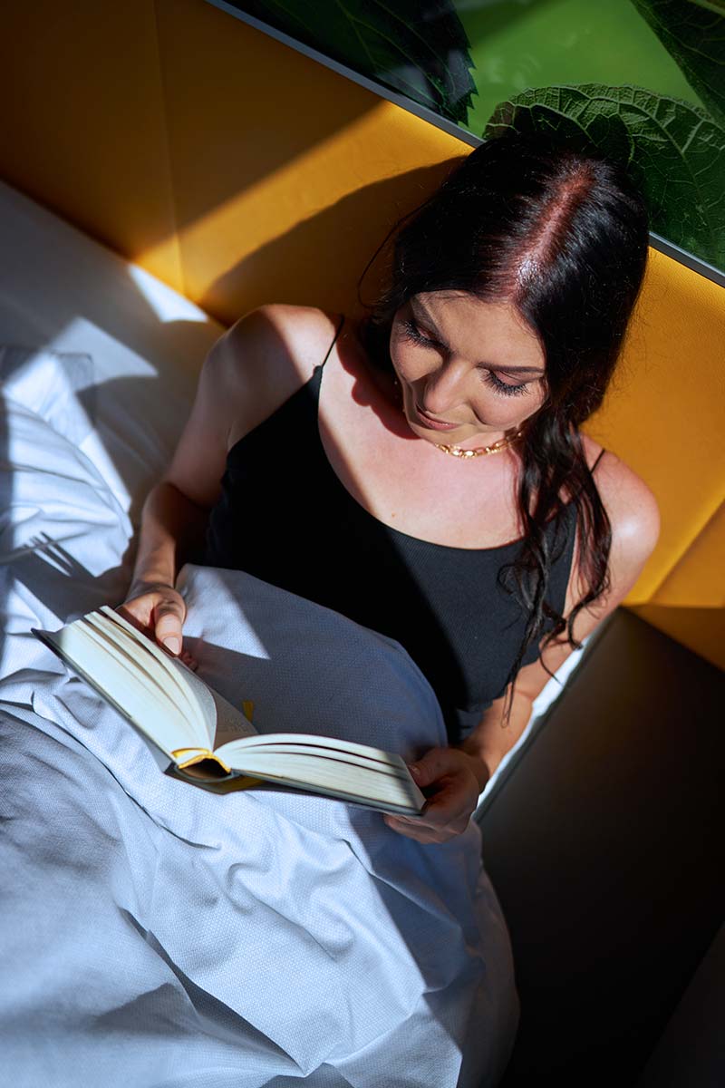 Frau liest Buch im Bett
